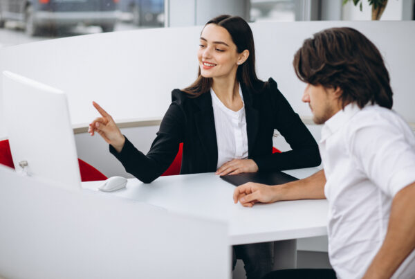 Man talking with female sales person in a car show room
